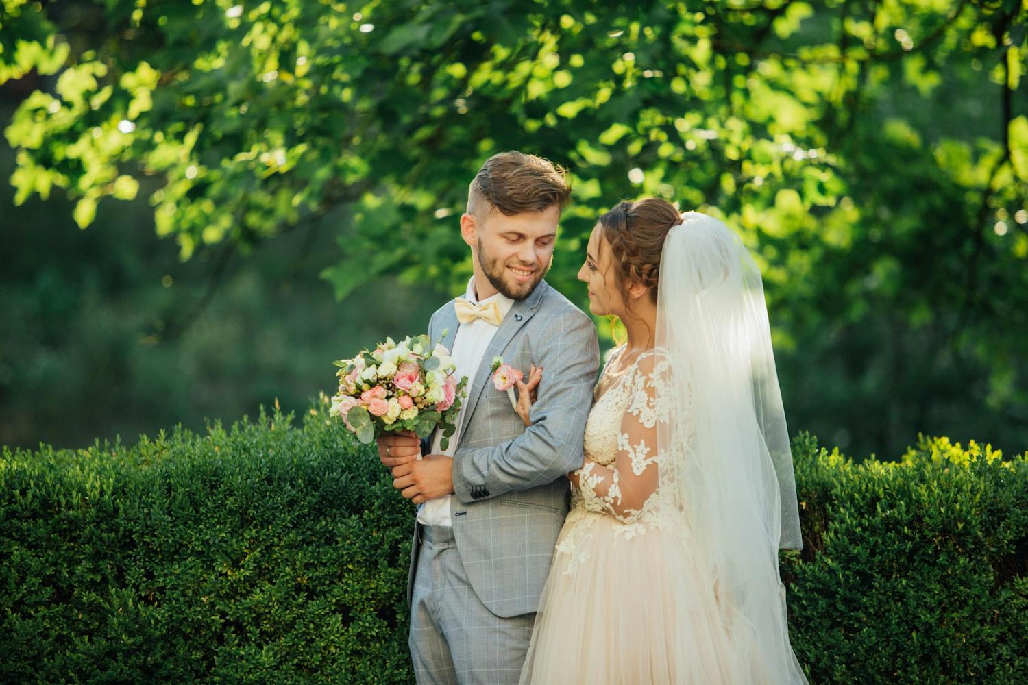 Brudepar under trær i solskinn